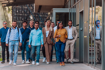 Image showing A diverse group of businessmen and colleagues walking together by their workplace, showcasing collaboration and teamwork in the company.