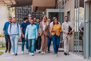 Image showing A diverse group of businessmen and colleagues walking together by their workplace, showcasing collaboration and teamwork in the company.