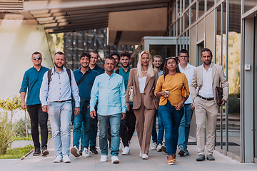 Image showing A diverse group of businessmen and colleagues walking together by their workplace, showcasing collaboration and teamwork in the company.