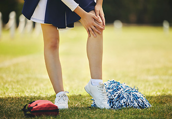 Image showing Cheerleader, injury and person with knee pain from sport, training and cheer exercise on a grass field. Health, accident and leg muscle bruise outdoor with emergency or workout challenge for wellness
