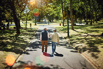 Image showing Men, friends walking and talking in park, nature and outdoor in retirement with support, communication or bokeh. Mature, people and back on path in New York with conversation and social community