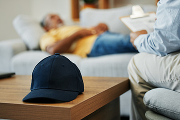 Image showing Cap, help and man in therapy for stress, conversation and discussion about mental health. Anxiety, psychology and closeup of hat on table in counseling for advice, notes or support from psychologist