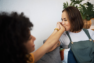 Image showing Kiss, love and lesbian couple holding hands in home for romance, bonding and commitment for partner. Smile, intimate and gay woman together in living room for support, healthy relationship and LGBTQ