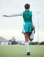 Image showing Back, sports and a woman hockey player stretching for the start of a game or competition outdoor. Balance, fitness and warm up with the legs of an athlete getting ready for training on a field