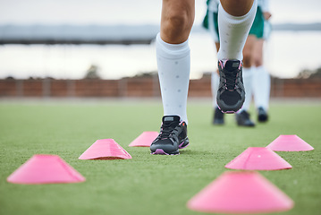 Image showing Cone, legs or athlete running for speed training, workout and warm up exercise on a outdoor hockey turf. Footwear closeup, healthy or sports person on grass playing in a practice game for fitness