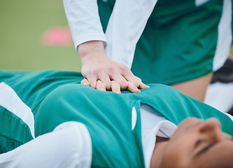 Image showing Hands, first aid and cpr with a hockey player on a field to save a player on her team after an accident. Fitness, heart and emergency attack with a woman helping her friend on a field of grass