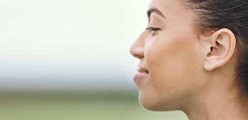 Image showing Face, mockup or hearing aid and a sports woman outdoor with an implant for sound or audio improvement. Profile, deaf and happy young athlete with an ear disability or impairment at training on space