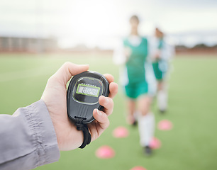 Image showing Hands, coach or team with stop watch on field to monitor time, fitness training or exercise progress. Hockey, performance blur or fast sports athlete with timer to check running workout or wellness