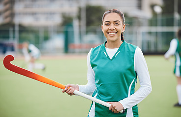 Image showing Female, person and happy for hockey with stick in hand on field for training in portrait. Girl, hold and smile with confidence for sports with pose, stand and equipment for match, game or fitness
