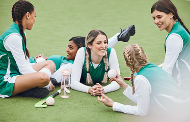 Image showing Women, team and hockey player on field, talking and relaxing after match, smile and workout. Conversation, happiness and positive for sports, fitness and exercise together for unity, game and health