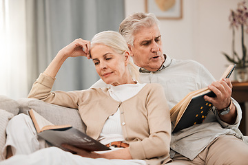 Image showing Old couple on sofa, reading book and relax together at home, retirement and wellness with love and comfort. Trust, care and support in marriage, share hobby with partner for knowledge and story