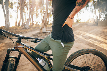 Image showing Cycling, man and bike with back pain in nature of training, exercise and workout outdoor in forest. Bicycle, person and fitness with injury from adventure, travel and strain in summer or woods