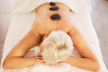 Image showing Senior woman, spa and wellness with stone, massage and relax with health, stress relief and luxury. Salon treatment, elderly person and pensioner with care, resting and spine with beauty and rock