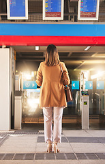 Image showing Walking, back and a woman at a station for a train, travel and entrance at a platform. Standing, waiting and a person entering a subway or gate for transportation, public traveling or transit