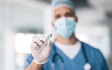 Image showing Man, doctor and hand with needle for vaccine, injection or antibiotic for healthcare or medical cure at hospital. Closeup of male person, nurse or surgeon with mask, gloves and flu shot at clinic
