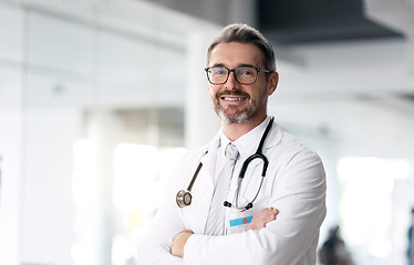 Image showing Happy doctor, portrait and man with arms crossed in hospital for healthcare, wellness or career. Face, medical professional smile and confident surgeon, expert or mature employee in glasses in Canada