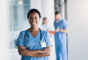 Image showing Happy, nurse and portrait of black woman with arms crossed in hospital for healthcare, wellness and nursing career. Face of African surgeon, confident medical professional worker and employee smile