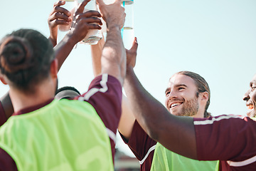 Image showing Soccer team, water bottle and exercise cheers with teamwork, achievement and community on grass field. Fitness, workout and sport training of men group with smile and celebration from game with drink