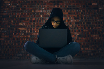 Image showing Hacker, woman in basement with laptop and information technology, phishing and cyber crime with database or server. Cybersecurity, programming and criminal with pc, ransomware and firewall breach