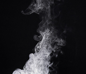 Image showing Smoke, mist or gas in a studio with dark background by mockup space for magic effect with abstract. Incense, steam or vapor fog moving in air for cloud smog pattern by black backdrop with mock up.