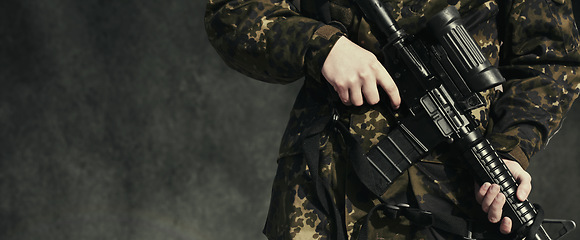 Image showing Soldier, war and holding a gun, closeup and mockup for army, military and camouflage for survival. Warrior, violence and crime by hands, battle and and danger on battlefield, safety and training