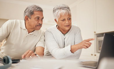 Image showing Senior couple, laptop and pointing in budget planning, finance or retirement together at home. Mature man and woman in serious discussion or investment on computer with financial documents in kitchen