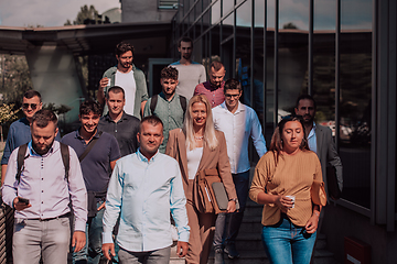 Image showing A diverse group of businessmen and colleagues walking together by their workplace, showcasing collaboration and teamwork in the company.