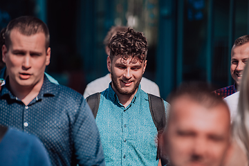 Image showing A diverse group of businessmen and colleagues walking together by their workplace, showcasing collaboration and teamwork in the company.