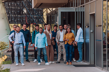 Image showing A diverse group of businessmen and colleagues walking together by their workplace, showcasing collaboration and teamwork in the company.