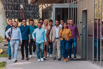 Image showing A diverse group of businessmen and colleagues walking together by their workplace, showcasing collaboration and teamwork in the company.