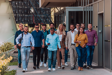 Image showing A diverse group of businessmen and colleagues walking together by their workplace, showcasing collaboration and teamwork in the company.