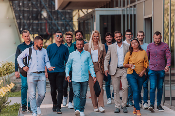 Image showing A diverse group of businessmen and colleagues walking together by their workplace, showcasing collaboration and teamwork in the company.