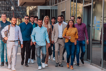 Image showing A diverse group of businessmen and colleagues walking together by their workplace, showcasing collaboration and teamwork in the company.