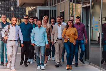 Image showing A diverse group of businessmen and colleagues walking together by their workplace, showcasing collaboration and teamwork in the company.