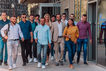 Image showing A diverse group of businessmen and colleagues walking together by their workplace, showcasing collaboration and teamwork in the company.