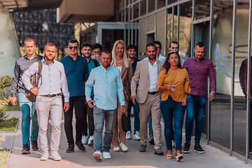 Image showing A diverse group of businessmen and colleagues walking together by their workplace, showcasing collaboration and teamwork in the company.