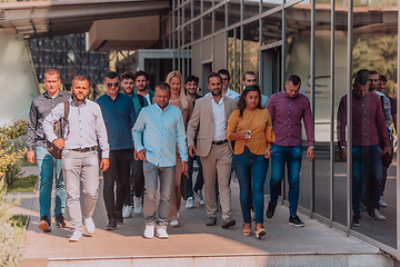 Image showing A diverse group of businessmen and colleagues walking together by their workplace, showcasing collaboration and teamwork in the company.