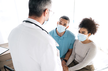Image showing Hospital conversation, couple and doctor consulting on medical consultation, gynecology news or wellness health support. Gynecologist discussion, face mask and marriage people listening to feedback