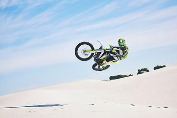 Image showing Desert, motorbike and man jump for sport stunt outdoor, adventure and travel. Off road, air and driver on motorcycle on sand in nature for action, competition energy and freedom for extreme challenge