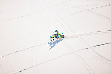 Image showing Above, man and driving motorbike on sand for sport, adventure or outdoor track in summer or mockup space. Motorcycle, ride and athlete on dirt, dune or desert for race, danger and fearless challenge