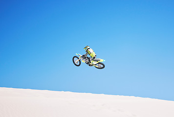 Image showing Motorbike, jump and man in the air with blue sky, mock up and stunt in sports with fearless person in danger with freedom. Motorcycle, jumping and athlete training for challenge or competition