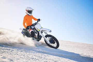 Image showing Sport, motorbike and athlete with desert with sand on wheels, pride and skill for adrenaline. Biker, sunshine and dust with blue sky in fun, fitness and achievement in speed, race or dubai vacation