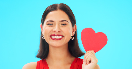 Image showing Portrait, happy and woman with paper heart in studio isolated on a blue background mockup space. Face smile, romance and model with love sign for anniversary symbol, emoji and care on valentines day