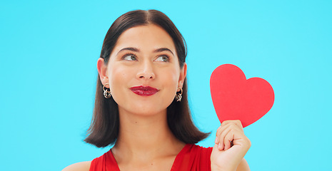 Image showing Thinking, happy and woman with paper heart in studio isolated on a blue background mockup. Idea, romance and model with love sign for anniversary, emoji and smile for valentines day gift or present