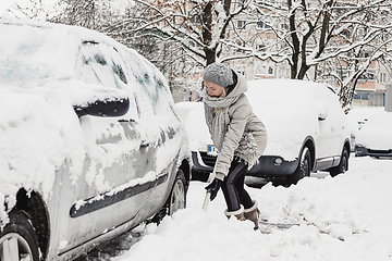 Image showing Independent woman shoveling snow in winter.