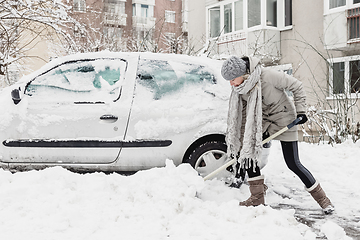 Image showing Independent woman shoveling snow in winter.