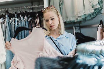 Image showing Beautiful woman shopping fashionable clothes in clothing store.