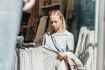 Image showing Beautiful woman shopping fashionable clothes in clothing store.