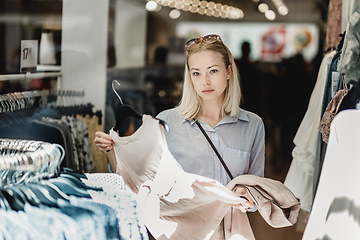 Image showing Beautiful woman shopping fashionable clothes in clothing store.