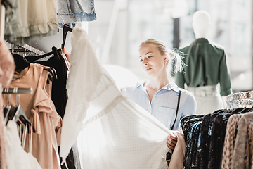 Image showing Beautiful woman shopping fashionable clothes in clothing store.